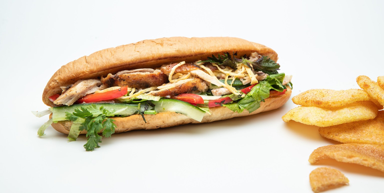 Sandwich baguette garni de poulet et légumes.