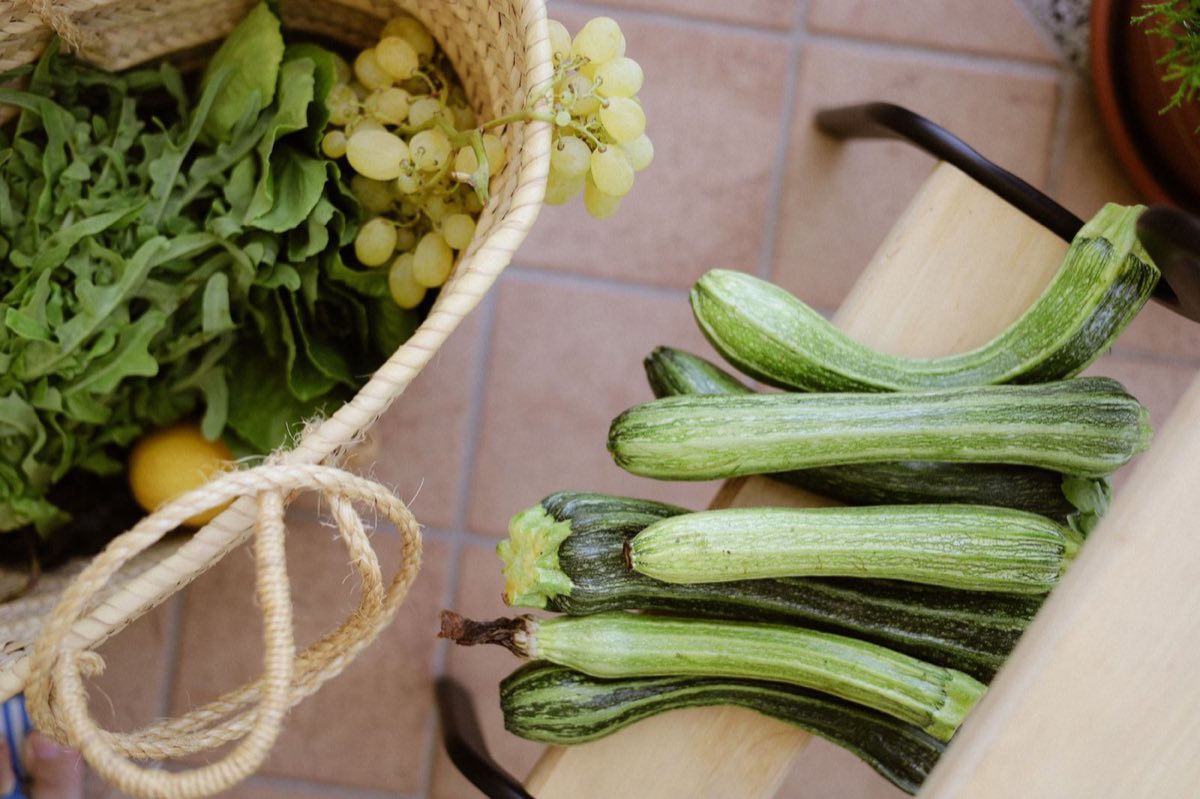 Légumes frais du jour, courgettes en cagette et panier de roquette