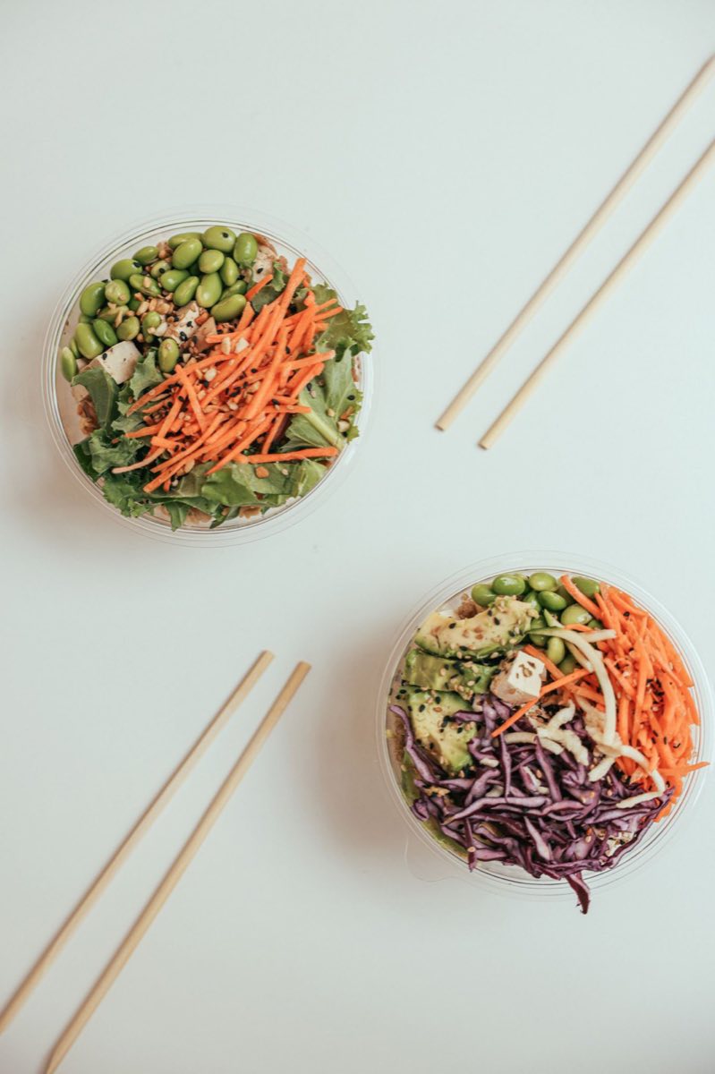 Deux salades composées vues de dessus : tofu, édamame, carotte râpée, chou rouge et avocat