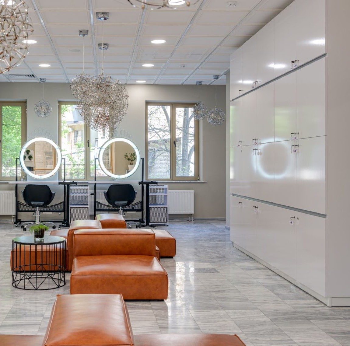 Intérieur du salon Lumen, miroirs ronds rétroéclairés, grandes fenêtres et assises en cuir cognac
