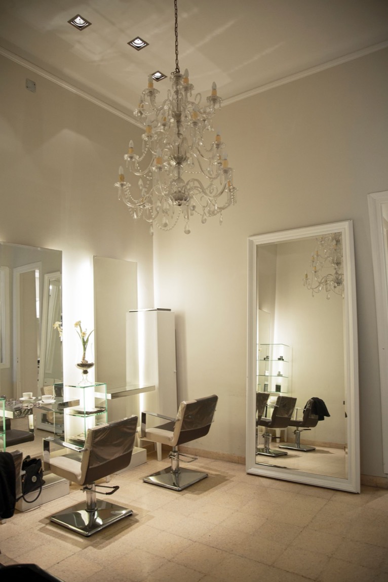 Salle du salon Lumen, murs crème, lustre en cristal et grand miroir